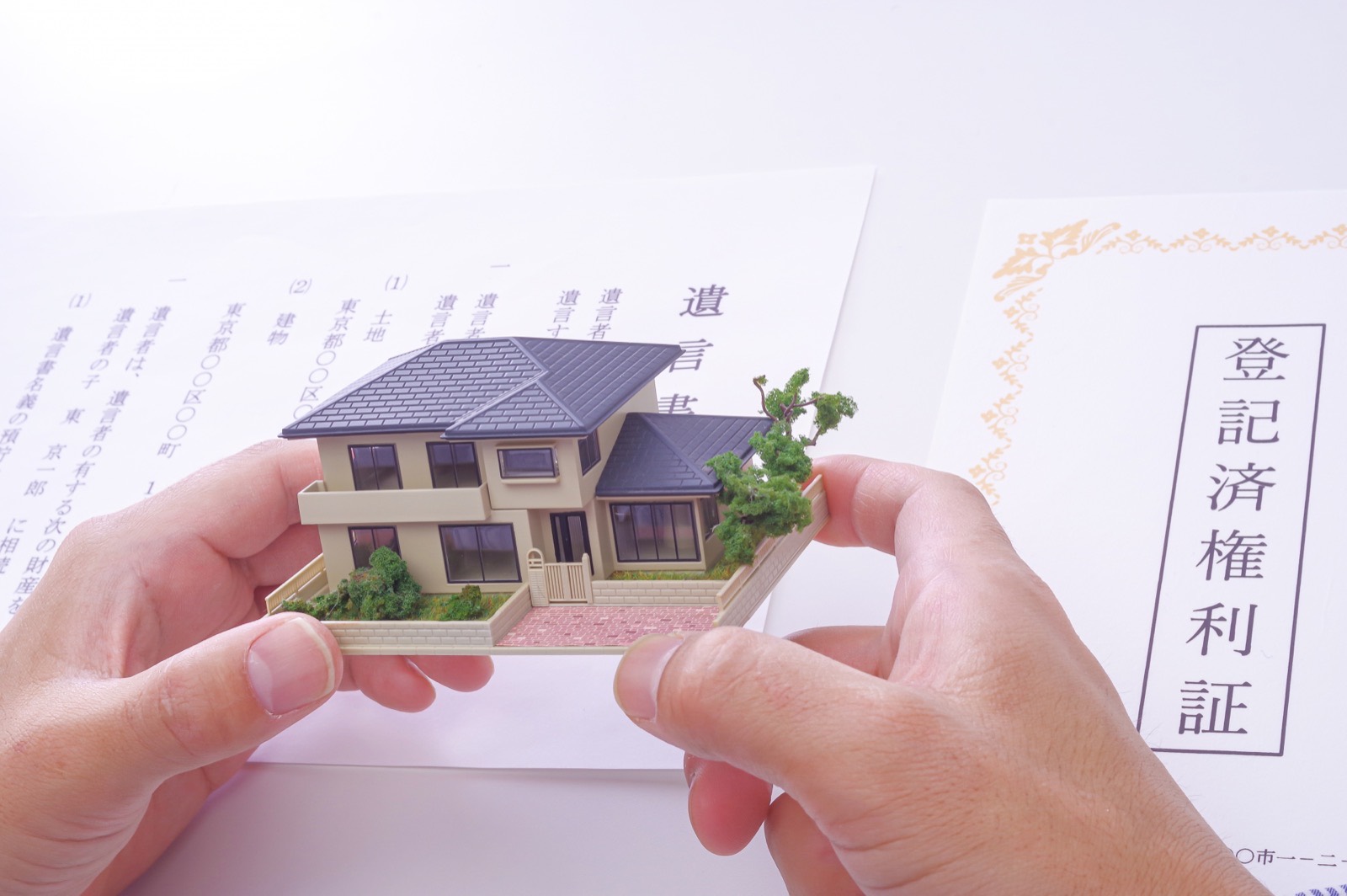 相続・登記に関する書類と住宅の模型